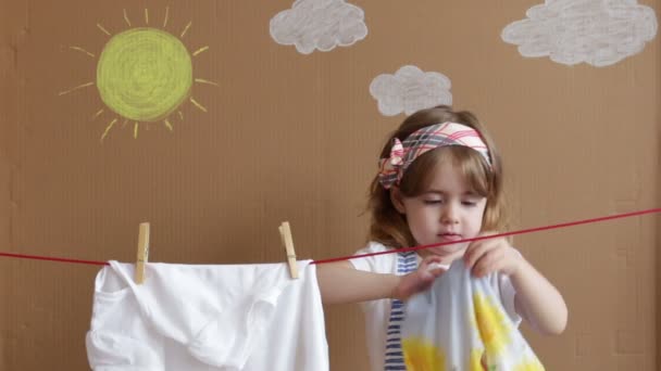 A menina bonita Hand Putting Clothespin e sai para secar uma roupa. Trabalho doméstico conceitual. bebê ajuda a mãe — Vídeo de Stock