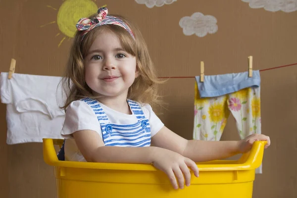 Niña está sentada en un baño amarillo — Foto de Stock