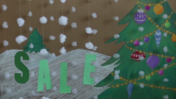 Señal de venta año nuevo. sobre el fondo de un árbol de Navidad pintado y nieve — Vídeo de stock