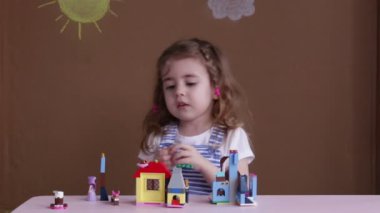 Şirin komik okul öncesi anaokulu odasında bir kule inşa inşaat oyuncak bloklarla oynama küçük kız.