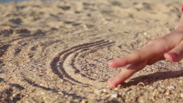 Mano femminile disegno segno infinito sulla sabbia . — Video Stock