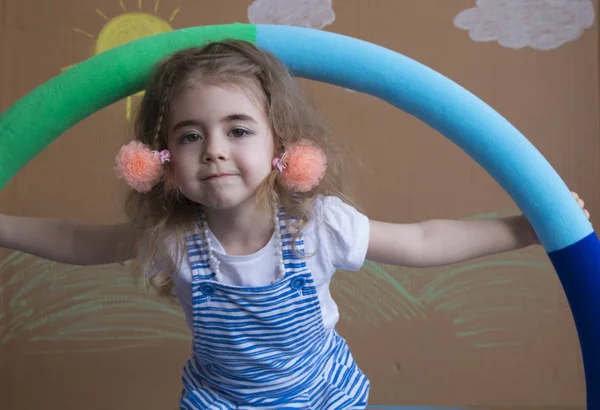 Emotional portrait little blonde girl and pigtails, holding a hoola hoop — Stock Photo, Image