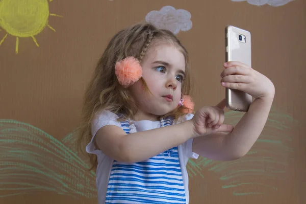 Portrait cute girl makes selfie with a cell phone. Adorable smiling toddler kid taking a selfie photo with smartphone — Stock Photo, Image