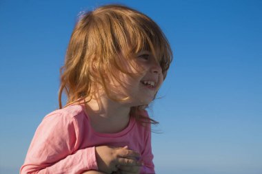 arka plan gökyüzü üzerinde küçük kız gülerek