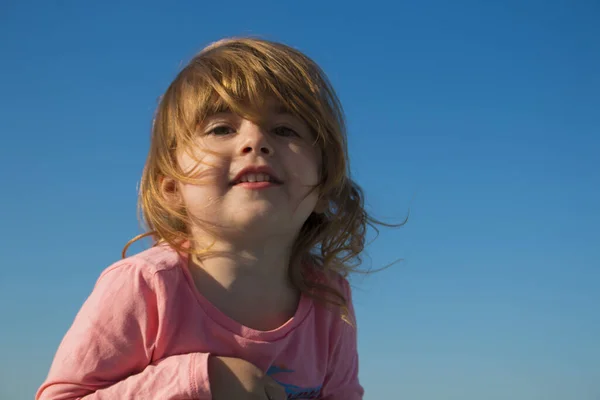 Riéndose niña en un fondo del cielo — Foto de Stock