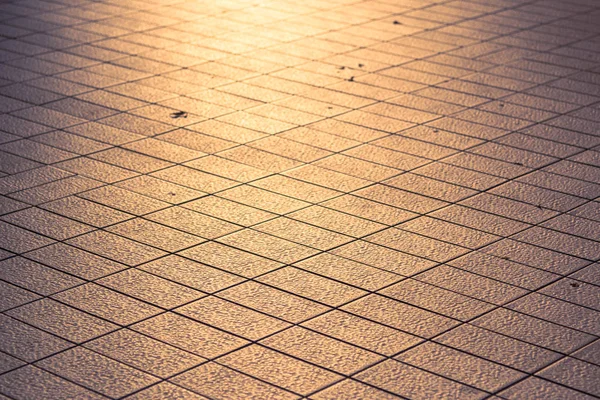 background texture of tile roads and the rays of the setting sun