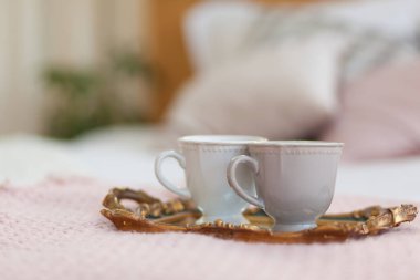 İki fincan kahve bir tepsi. Yatakta kahvaltı