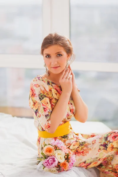 Hermosa chica en un vestido largo botones pendientes —  Fotos de Stock