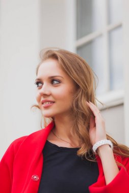 Kırmızı paltolu güzel sarışın kız portresi. Şehir sokak