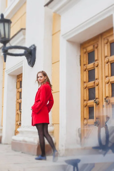 Retrato de uma linda menina loira de casaco vermelho. Rua da Cidade — Fotografia de Stock