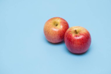 Mavi bir arka plan üzerinde kırmızı olgun elma