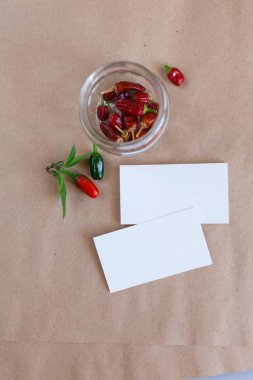 Kraft kağıt ve bir kartvizit mockup. Kapak broşürü. Cam kavanozda kırmızı biber