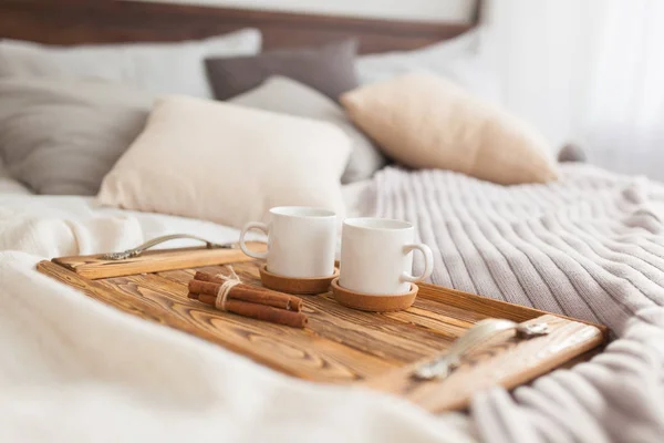 Bir tepsi beyaz iki kupalar tarçın çubuğu, Kahvaltı konsepti ile yatak