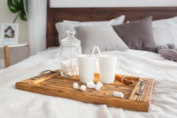 Bir tepsi beyaz iki kupalar tarçın çubuğu, Kahvaltı konsepti ile yatak