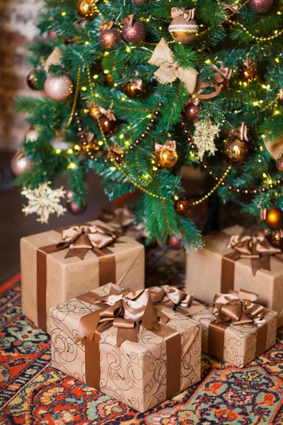 Brown boxes with Christmas gifts on the background of a Christmas tree