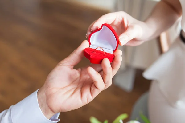 Manos masculinas con caja de terciopelo rojo que contiene anillo de compromiso con brillante — Foto de Stock