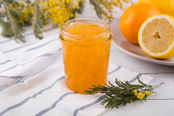 Sliced oranges and orange jam in a glass jar — Stock Photo, Image