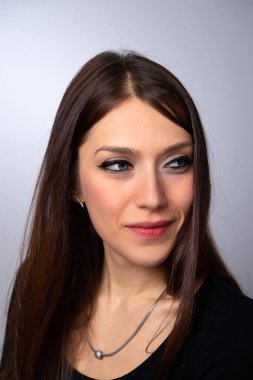 Beyaz arka planda izole edilmiş uzun düz saçlı esmer kız portresi.