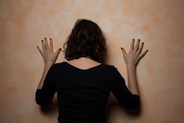 Kahverengi saçlı kadının dikiz aynasındaki bej duvara yaslanışı. Aile içi şiddetin depresyondaki kadın kurbanı. Kadınlara karşı şiddet kavramı