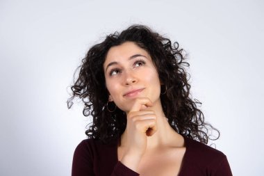 Dalgın ve rüya gibi görünen kıvırcık saçlı esmer kızın portresi.