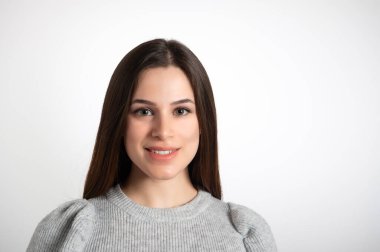 Genç, gülümseyen esmer kadın portresi. Mükemmel temiz ciltli, düz, uzun kahverengi saçlı ve kameraya bakan bir kadın model. Beyaz arkaplanda izole edilmiş, boşluğu kopyala