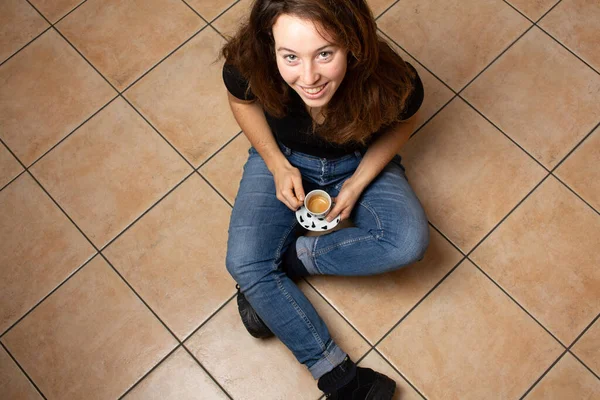 Jovem Morena Atraente Alegre Jeans Sentado Chão Azulejos Bege Segurando — Fotografia de Stock