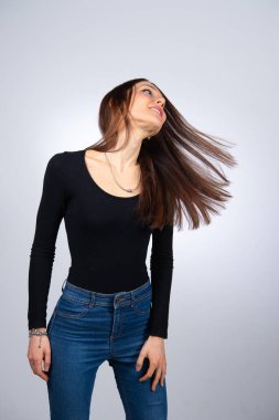 Kadın modelin uzun düz saçlarını yana doğru çevirdiğini düşün.