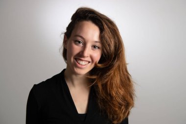 Çekici, gülümseyen esmer bir kızın portresi. Beyaz arka planda izole edilmiş. Güzellik ve saç stili kavramı