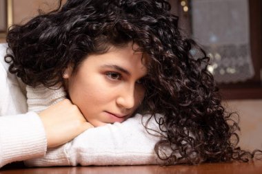 Düşünceli bir ifadeyle siyah saçlı kızın yakın çekimi.