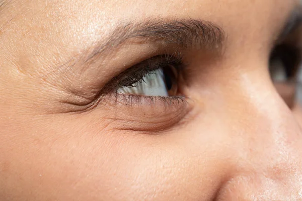 A closeup view on the eye and cheek area of a Caucasian lady, eyesight and skincare concept.