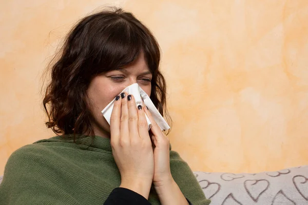 Nette Braunhaarige Frau Sitzt Auf Der Couch Und Pustet Ihre — Stockfoto