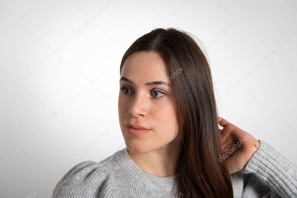 Portrait of beautiful brunette female model looking to the side. Young pretty woman with brown long straight hair