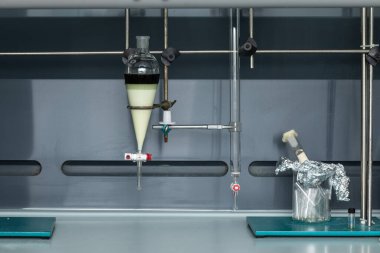 Boruları ve cam kabı olan laboratuvar ekipmanları.