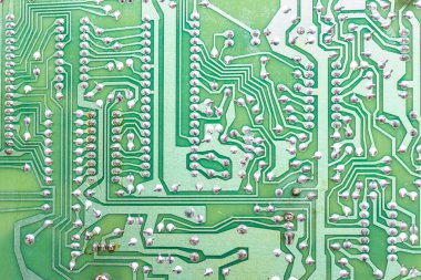 Yazdırılmış devre kartının (PCB) lehimleme ve iletken izlerini gösteren yakın plan detaylı bir görüntüsü. Bağlantı ve teknoloji kavramı.