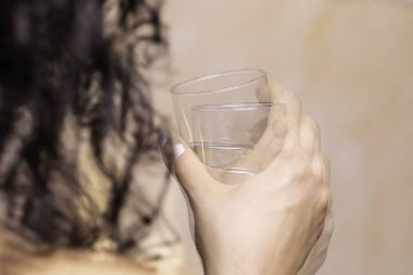 Kadının el sıkışırken, Parkinson hastalığından muzdarip bardak içerken yakından çekilmiş görüntüsü.