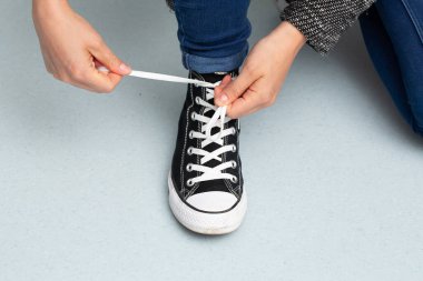 Ayakkabılarını bağlayan kız.