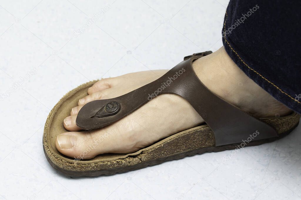 Female foot in leather flip flop top view