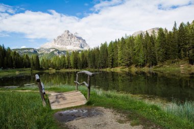 Dağların yakınındaki bir gölette köprüsü olan manzara