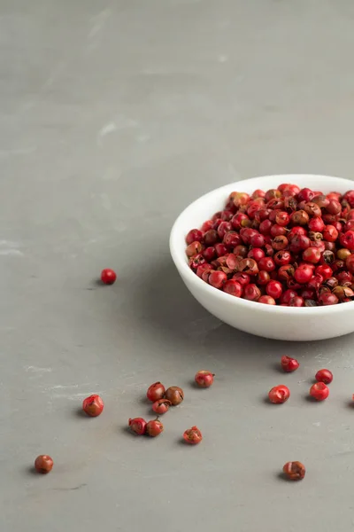 Pimenta rosa em um fundo cinza Fechar — Fotografia de Stock