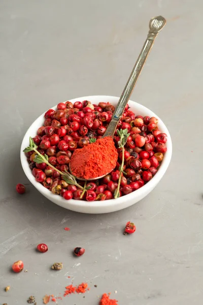 pembe peppercorns ve gri arka plan üzerinde toz biber