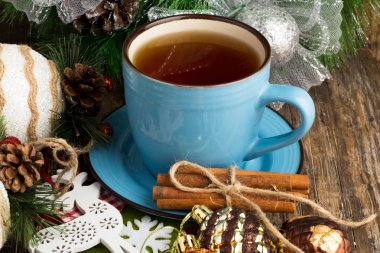 Tarçın, mavi yılbaşı ağacı süsleri karanlık bir arka plan üzerinde çay kupa