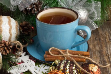Ahşap arka plan, bir bardak çay ve yılbaşı ağacı süsleri