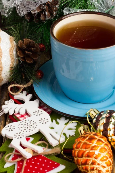 Blue cup of tea and Christmas toys — Stock Photo, Image