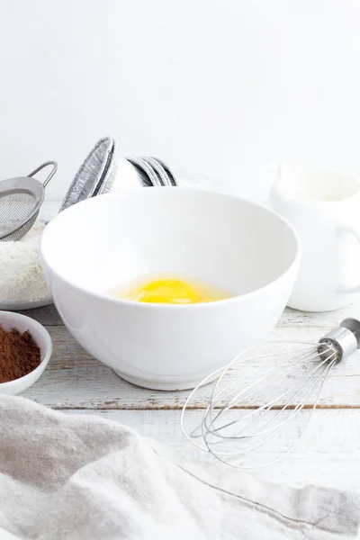 Schüssel mit Mehl, Eiern, Kakao und Milch auf weißem Hintergrund Nahaufnahme — Stockfoto