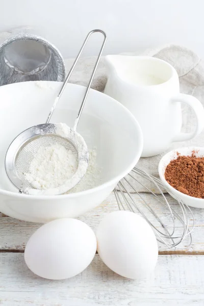 Schüssel mit Mehl, Eiern, Kakao und Milch in Nahaufnahme — Stockfoto