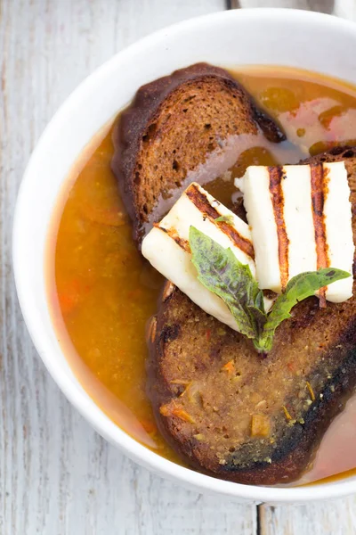 Sopa de legumes com pão, queijo e ervas em um fundo de madeira — Fotografia de Stock