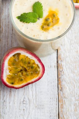 Bir bardak beyaz zemin üzerinde bir saman ile smoothies tutku meyve, süt ve chia tohum