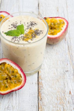 Bir bardak beyaz bir arka plan üzerinde smoothies tutku meyve, süt ve chia tohum