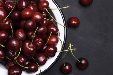 Siyah bir zemin üzerine bir tabak yakın çekim kiraz