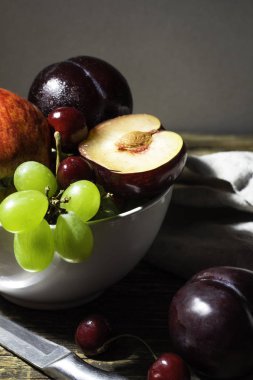 Erik, elma, üzüm ve kiraz ahşap bir masa üzerinde